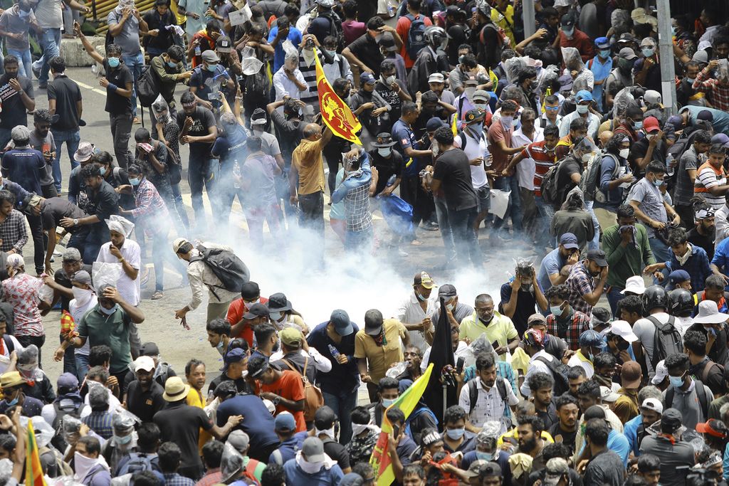 Pengunjuk rasa bereaksi setelah polisi melontarkan gas air mata pada demonstrasi di Colombo, Sri Lanka, Sabtu (9/7/2022). 