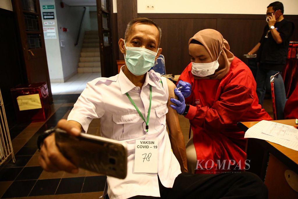 Warga berswafoto saat menerima suntikan vaksin Covid-19 dosis ketiga di GPIB Paulus, Menteng, Jakarta Pusat, Rabu (19/1/2022). 