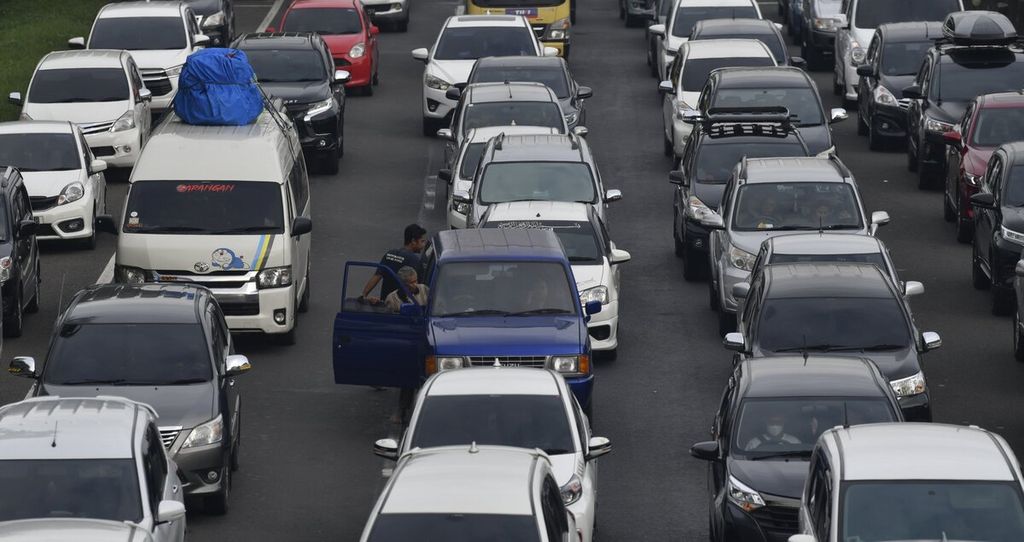 Pengendara bertukar posisi mengemudi di tengah kemacetan yang terjadi selepas Gerbang Tol Cikampek Utama, Purwakarta, Jumat (29/4/2022). Volume kendaraan dari Jakarta yang menuju ke arah timur terus meningkat pada H-3 Lebaran.