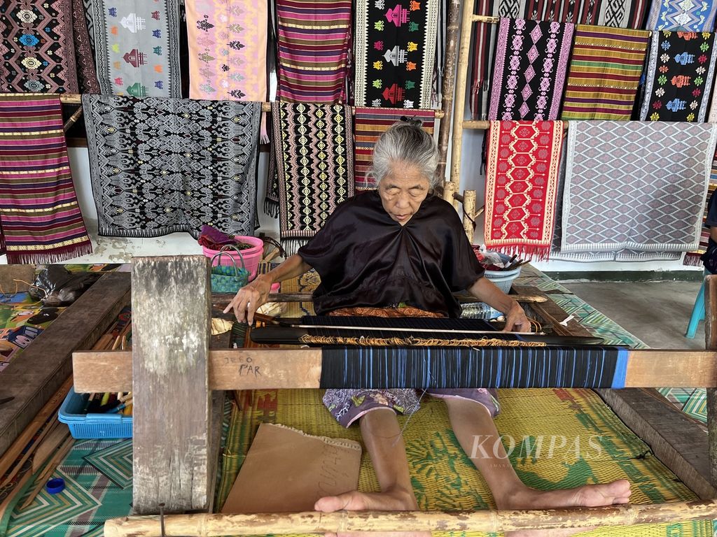 Jero Pur menenun di teras Patuh Artshop, Desa Sukarara, Kecamatan Jonggat, Lombok Tengah, NTB, Kamis (6/7/2023). Ia adalah satu dari ribuan perempuan penenun di Desa Sukarara.