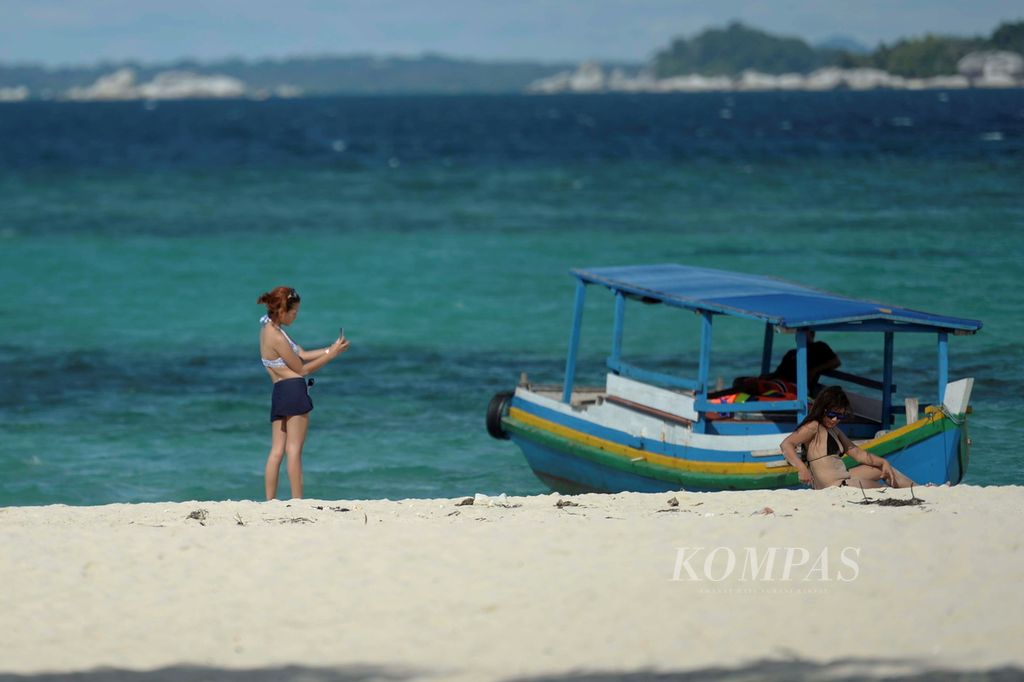 Wisatawan berfoto di tepi pantai Pulau Lengkuas, Belitung, Kepulauan Bangka-Belitung, Senin (13/6/2016).
