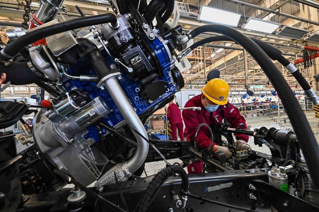 Karyawan bekerja di jalur perakitan truk di sebuah pabrik untuk perusahaan manufaktur kendaraan Jianghuai Automobile Group Corp (JAC) di Qingzhou, Provinsi Shandong, China timur, pada 15 Maret 2021. 