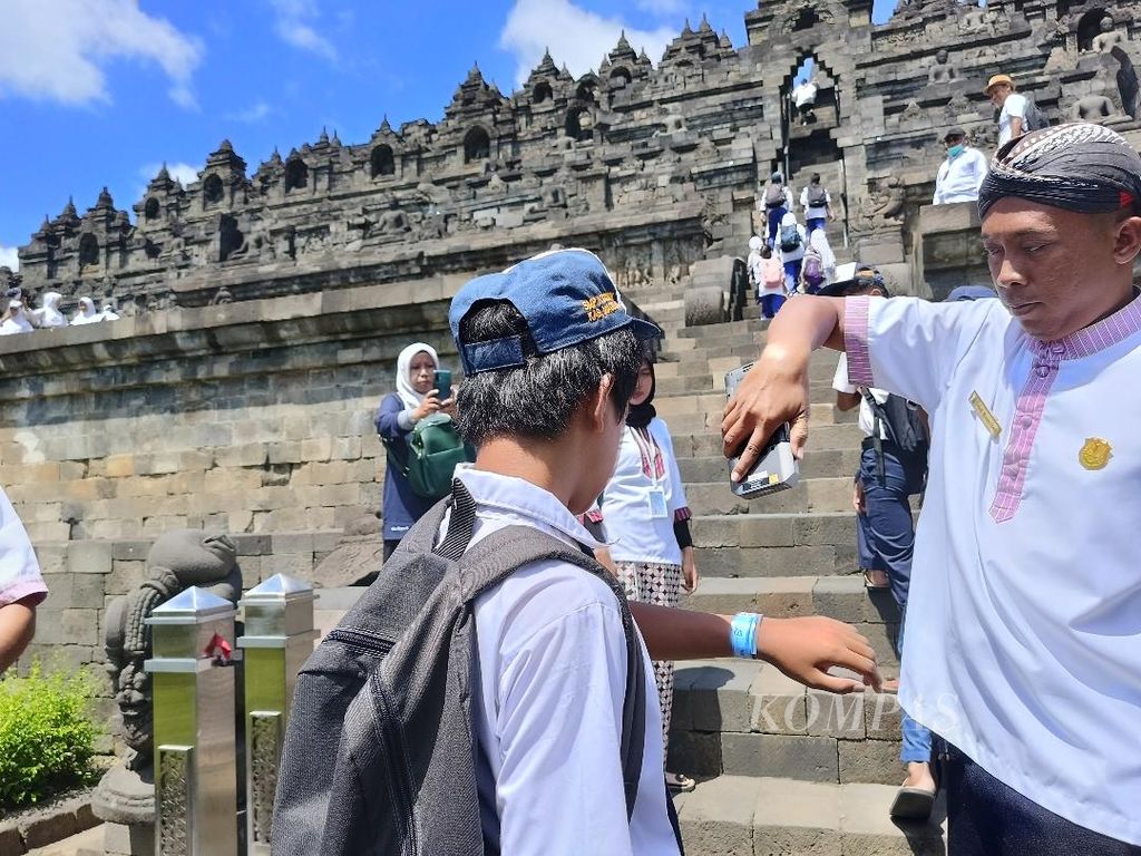 Sejumlah pelajar menunjukkan gelang pada tangan mereka untuk menjalani <i>scanning</i><i>barcode</i> sebelum naik ke bangunan Candi Borobudur, Kabupaten Magelang, Jawa Tengah, Senin (12/2/2024).