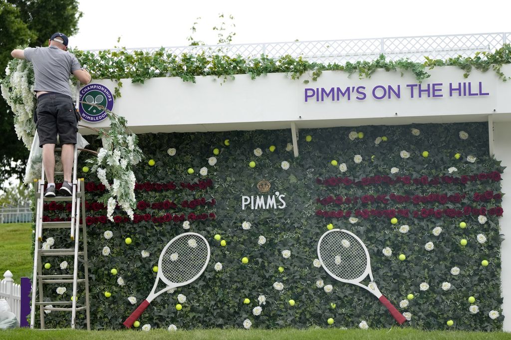 Pekerja merapikan pernak-pernik Wimbledon di London, Jumat (24/6/2022) lalu. 