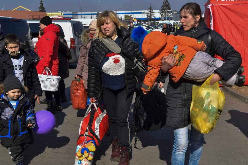 Para pengungsi, yang telah berhasil menyeberang perbatasan antara Ukraina dan Polandia, ditampung di sebuah tempat perlindungan sementara dan pusat relokasi di dekat Przemysl, Polandia tenggara, Minggu (13/3/2022). 