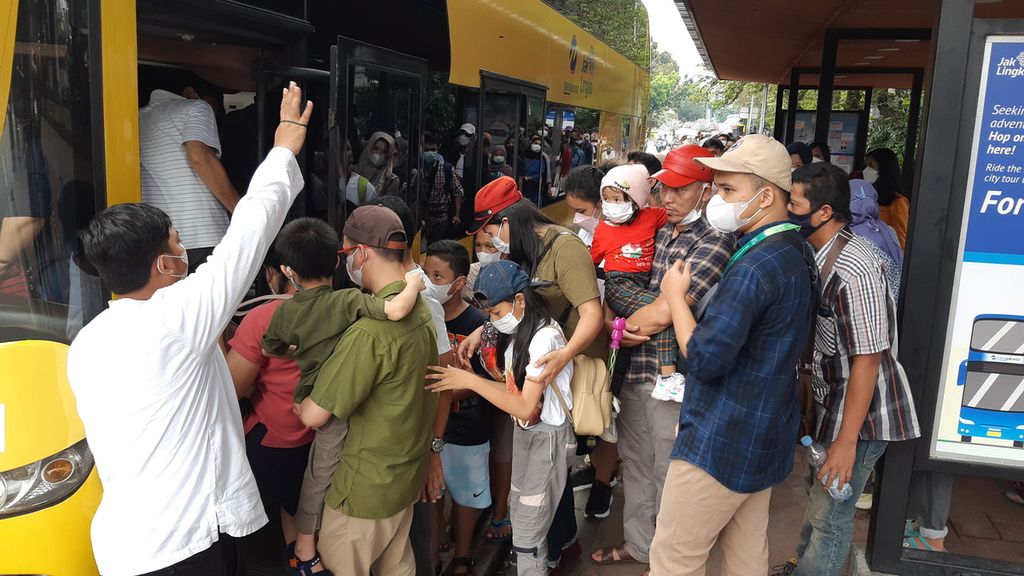 Antrean panjang calon penumpang terlihat di Halte IRTI, Monas, Jakarta Pusat, Selasa (3/5/2022). Hari itu merupakan  hari pertama layanan bus wisata diaktifkan kembali setelah dua tahun layanannya dihentikan karena pandemi Covid-19. 