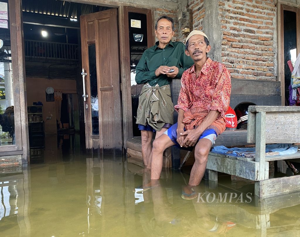 Warga duduk di teras rumahnya seusai bermaaf-maafan dengan tetangganya di Desa Sayung, Kecamatan Sayung, Kabupaten Demak, Jawa Tengah, Rabu (10/4/2024). Di desa yang terendam banjir setinggi 60 sentimeter itu, aktivitas yang biasa dilakukan warga saat Lebaran terganggu. 