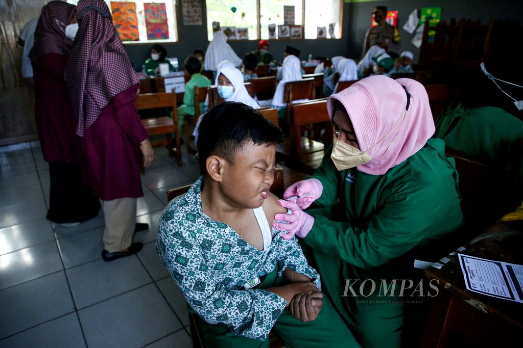 Seorang siswa menerima suntikan vaksin Covid-19 dosis pertama dalam kegiatan Vaksinasi Merdeka Anak di Madrasah Ibtidaiyah Al -Munawwaroh, Larangan, Kota Tangerang, Banten, Jumat (7/1/2022). 