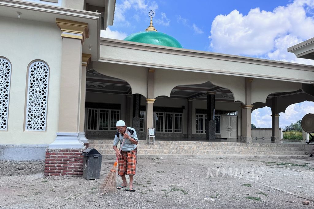 Sanadi (70) membersihkan halaman Masjid Nurul Iman, Dusun Kuang Jukut, Pringgarata, Lombok Tengah, Nusa Tenggara Barat, Minggu (24/3/2024).