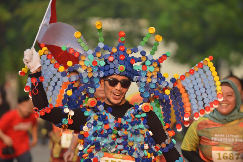 Seorang pelari yang mengenakan kostum ramah lingkungan dari tutup botol bekas berlari menuju garis finis dalam acara Bank Jateng Friendship Run di Lapangan Banteng, Jakarta, Minggu (21/5/2023). 