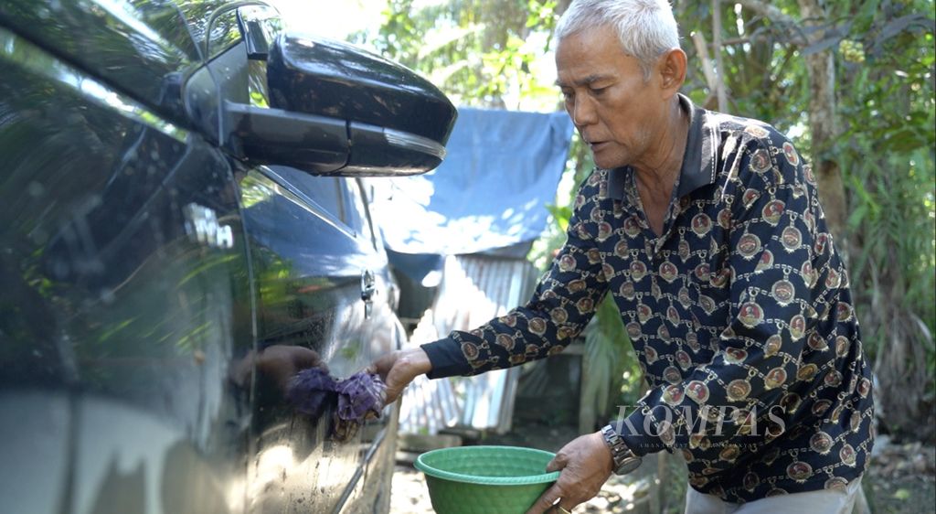 Kepala Adat Suku Balik di Kelurahan Sepaku sedang mencuci mobil pribadinya di samping rumahnya di Kecamatan Sepaku, Penajam Paser Utara, Kalimantan Timur, Selasa (5/11/2023).