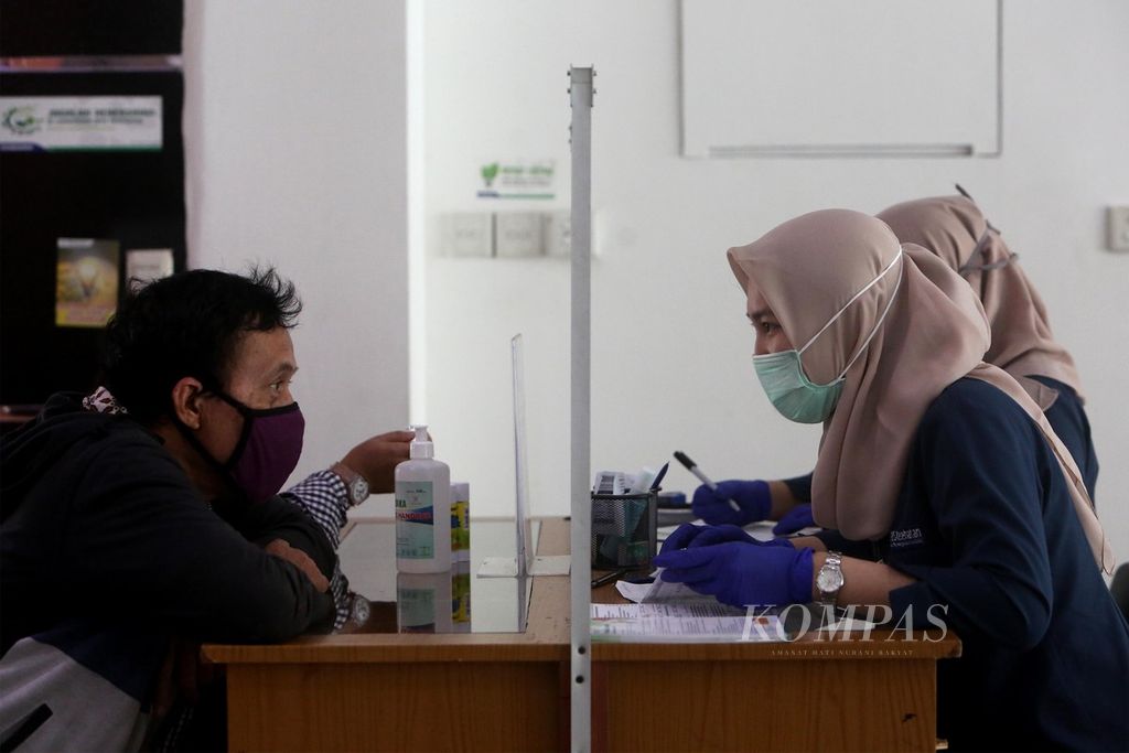 Warga mengurus administrasi di kantor BPJS Kesehatan Cabang Jakarta Selatan di Pancoran, Kamis (14/5/2020). Di tengah pandemi Covid-19, pemerintah memutuskan untuk menaikkan iuran BPJS Kesehatan. Padahal, sebelumnya dalam putusan pada 31 Maret 2020, Mahkamah Agung sudah membatalkan kenaikan iuran yang dibuat pemerintah pada 2019.