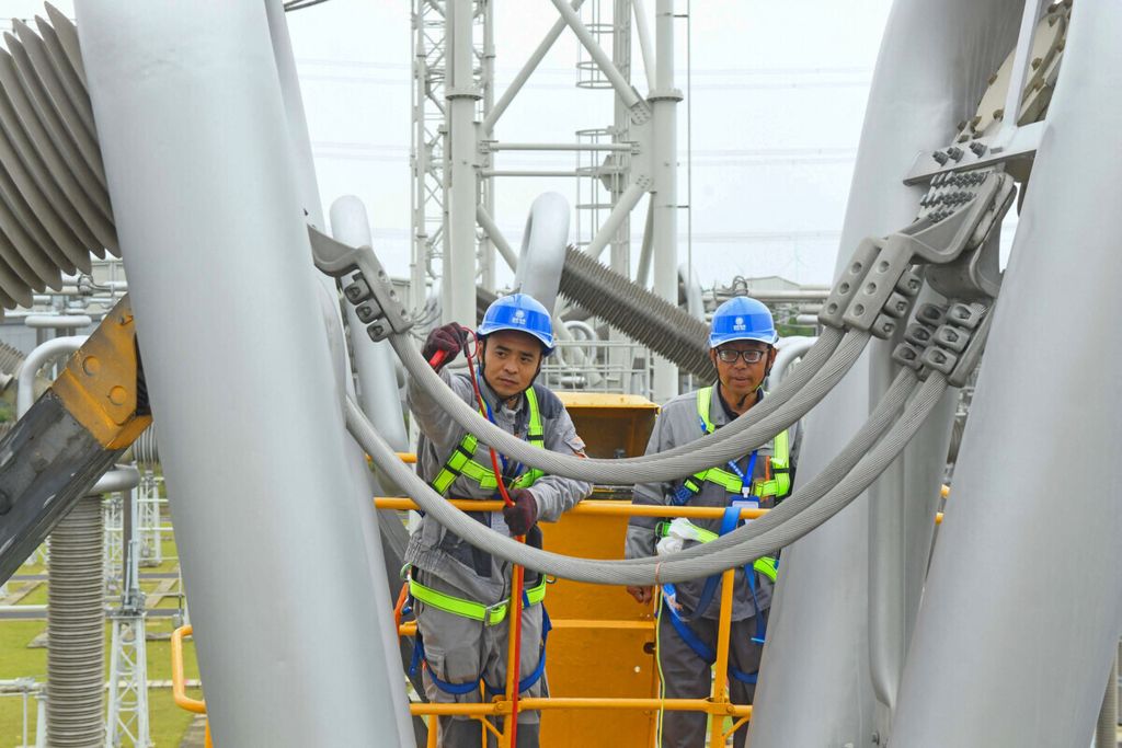 Foto yang diambil Oktober 2021 menunjukkan para pekerja memelihara stasiun konverter tegangan tinggi di Xuanchen, Provinsi Anhui, China. 