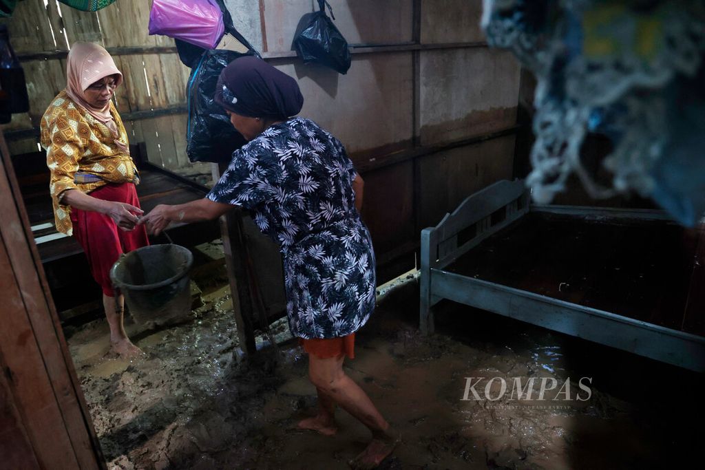 Warga membersihkan rumahnya dari lumpur sisa banjir bandang yang terjadi di Rowosari, Kecamatan Tembalang, Kota Semarang, Jawa Tengah, Sabtu (7/1/2022). 