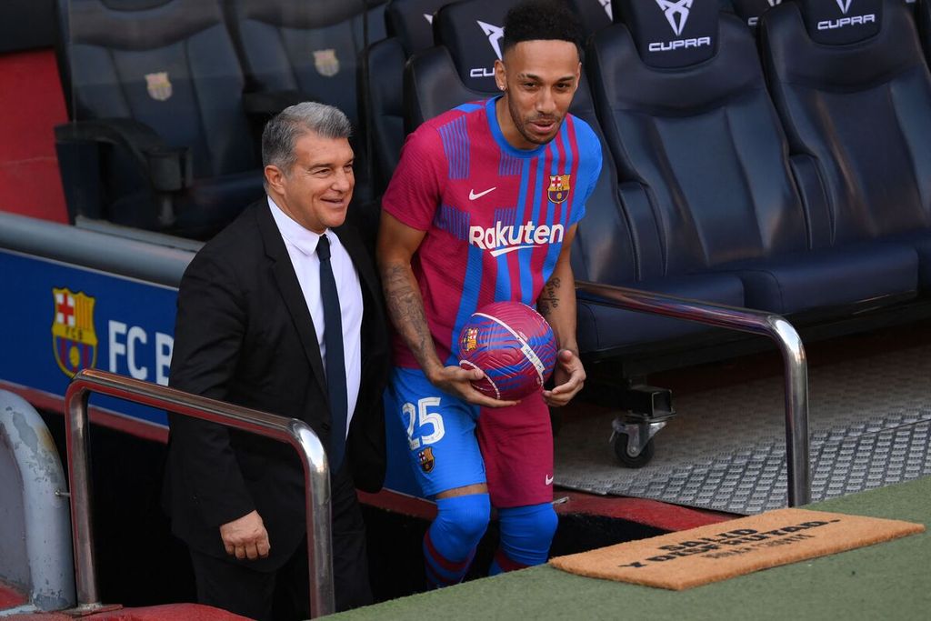 Striker baru Barcelona, Pierre-Emerick Aubameyang (kanan), didampingi Presiden Barcelona Joan Laporta masuk ke lapangan untuk sesi perkenalan resmi di Stadion Camp Nou, Barcelona, 3 Februari 2022.