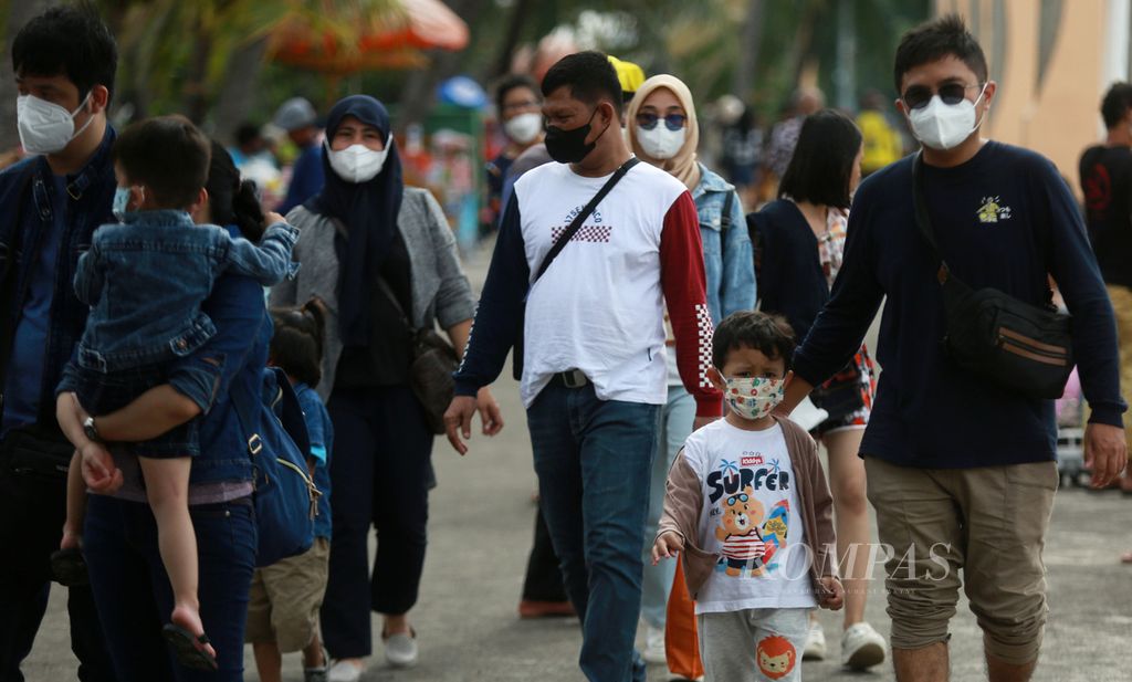 Pengunjung mengenakan masker saat berjalan di jalur pedestrian di kawasan Taman Impian Jaya Ancol, Jakarta Utara (28/2/2022). Sebagian warga ibukota memilih memanfaatkan hari libur Isra Mi'raj di tengah kota. Sebanyak 20.000 orang berkunjung di tempat wisata tersebut. Ancol merupakan salah satu tujuan utama wisata masyarakat Ibu Kota ketika masa liburan. 