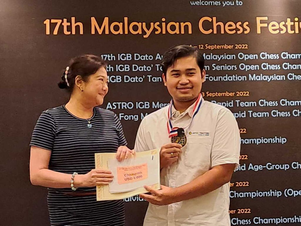 Pecatur Indonesia GM Novendra Priasmoro (kanan) menerima cek hadiah setelah menjuarai nomor catur klasik pada turnamen catur Malaysia Terbuka 2022, Minggu (11/9/2022) di Kuala Lumpur, Malaysia.