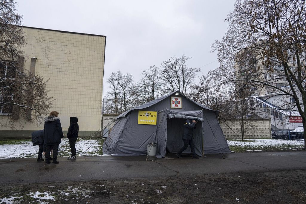 Warga berdiri di depan tenda berpemanas di Kyiv, Ukraina, 28 November 2022. 