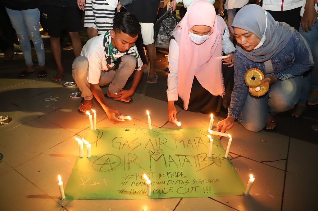 Warga menyalakan lilin bersama Forum Pimpinan Daerah (Forpimda) Kota Surabaya dalam doa bersama untuk korban tragedi Kanjuruhan, di Taman Surya, Surabaya, Jawa Timur, Selasa (4/10/2022) malam.