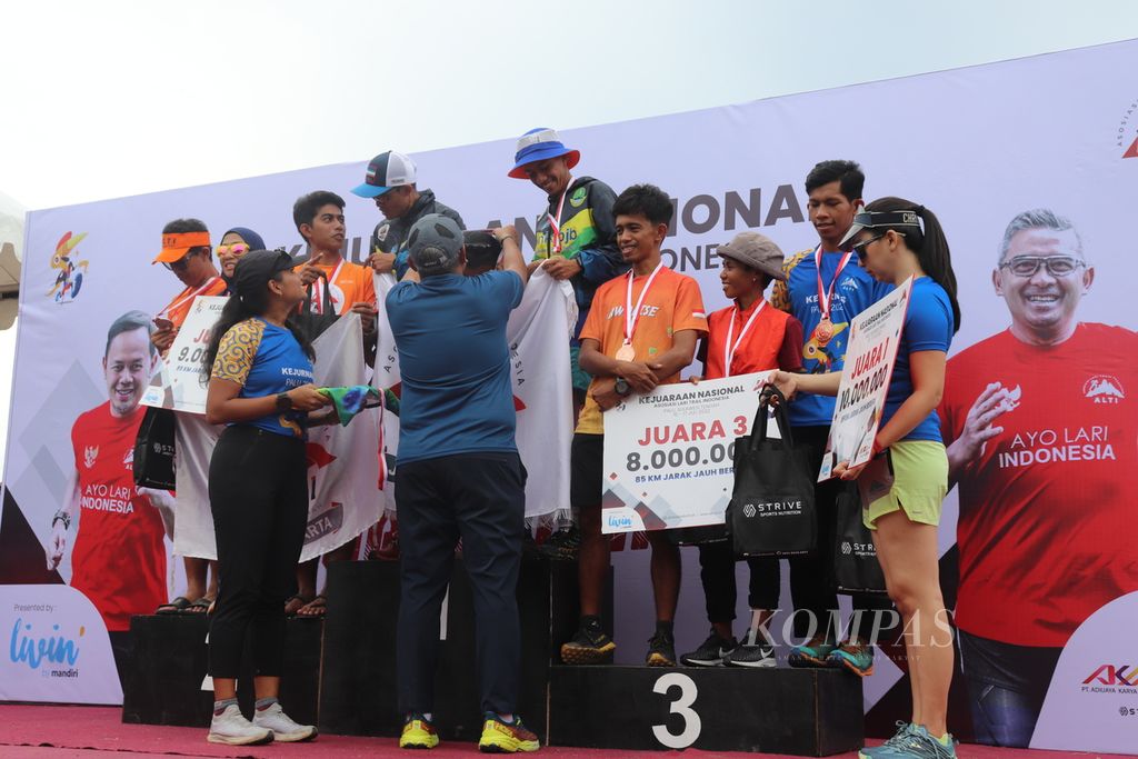 Para atlet mendapatkan kalungan medali dari panitia Kejuaraan Nasional Lari Trail di Desa Balane, Kecamatan Kinavaro, Kabupaten Sigi, Sulteng, Minggu (17/7/2022). Kejuaraan nasional ini baru pertama kali ini digelar.
