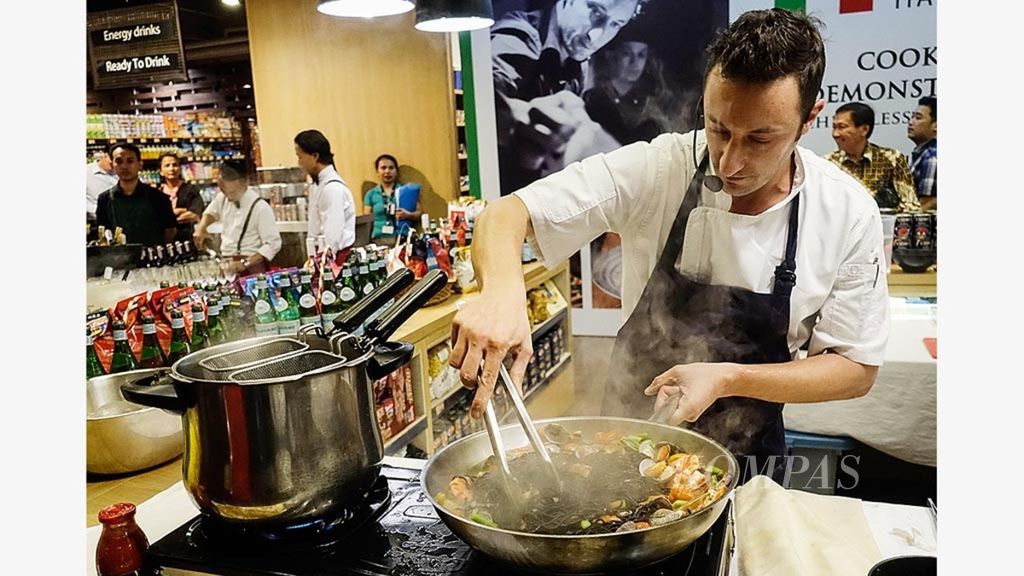 Chef Alessandro De Boni mempraktikkan cara memasak salah satu menu khas Italia, black ink tagliolini with seafood sauce, Jumat (17/11) di ajang Extraordinary Italian Taste di Ranch Market, Grand Indonesia, Jakarta.