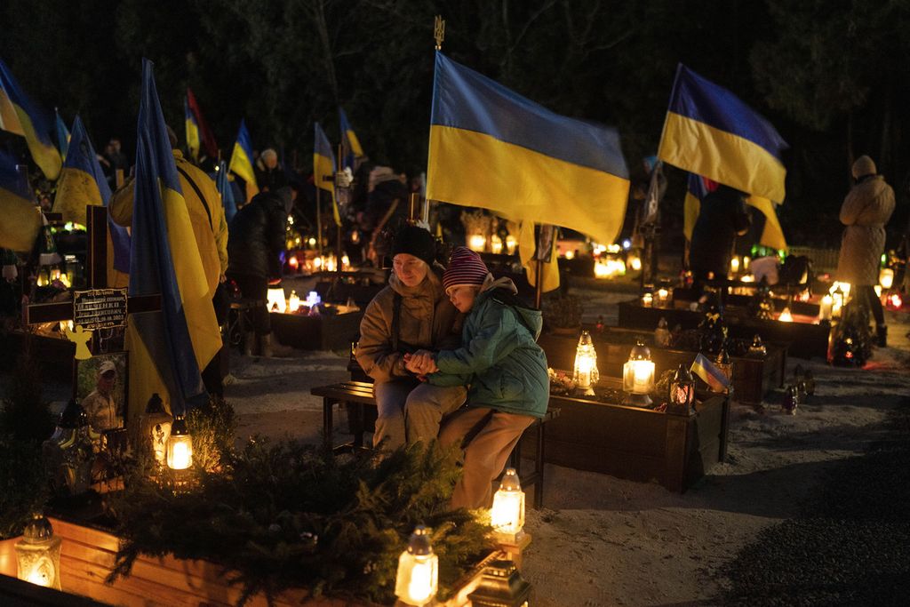 Keluarga korban perang Ukraina berziarah di salah pemakamam Lviv, Ukraina, Kamis (23/2/2023). 