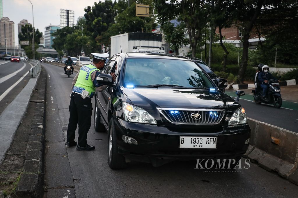Police stopped a car that was breaking through the Transjakarta bus lane on Jalan Letjen S Parman, West Jakarta, Monday (10/7/2023).
