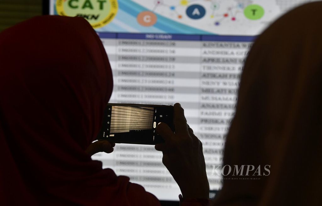Peserta penerimaan calon pegawai negeri sipil (CPNS) di lingkungan Pemerintah Provinsi DKI Jakarta yang sedang mengikuti seleksi kompetensi dasar (SKD) di Kantor Walikota Jakarta Selatan, melihat informasi yang ditampilkan pada layar di luar ruang ujian, Senin (17/2/2020). 