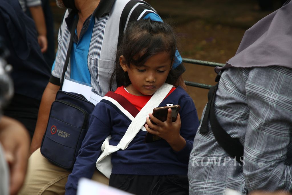 Seorang anak menggunakan gawai di kawasan Petamburan, Tanah Abang, Jakarta Pusat, Februari 2021.  