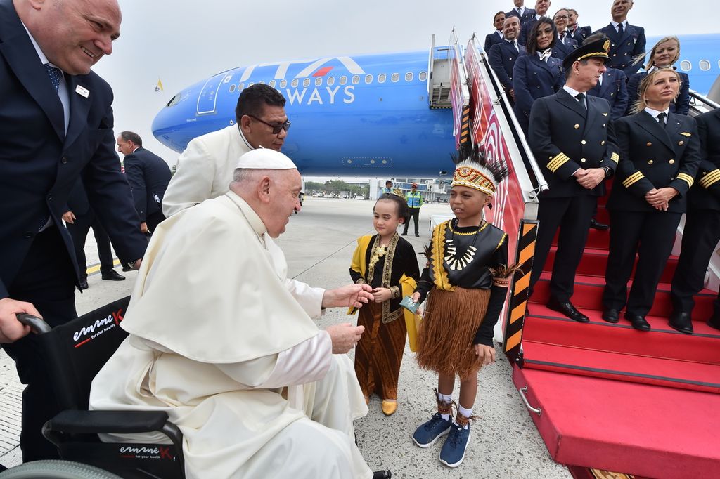  Paus Fransiskus menerima karangan bunga yang diberikan oleh dua orang anak berpakaian tradisional, Mary Lourdes Wicaksono Atmojo dan Irfan Wael, setibanya di Bandara Internasional Soekarno-Hatta, Tangerang, Banten, Selasa (3/9/2024). 