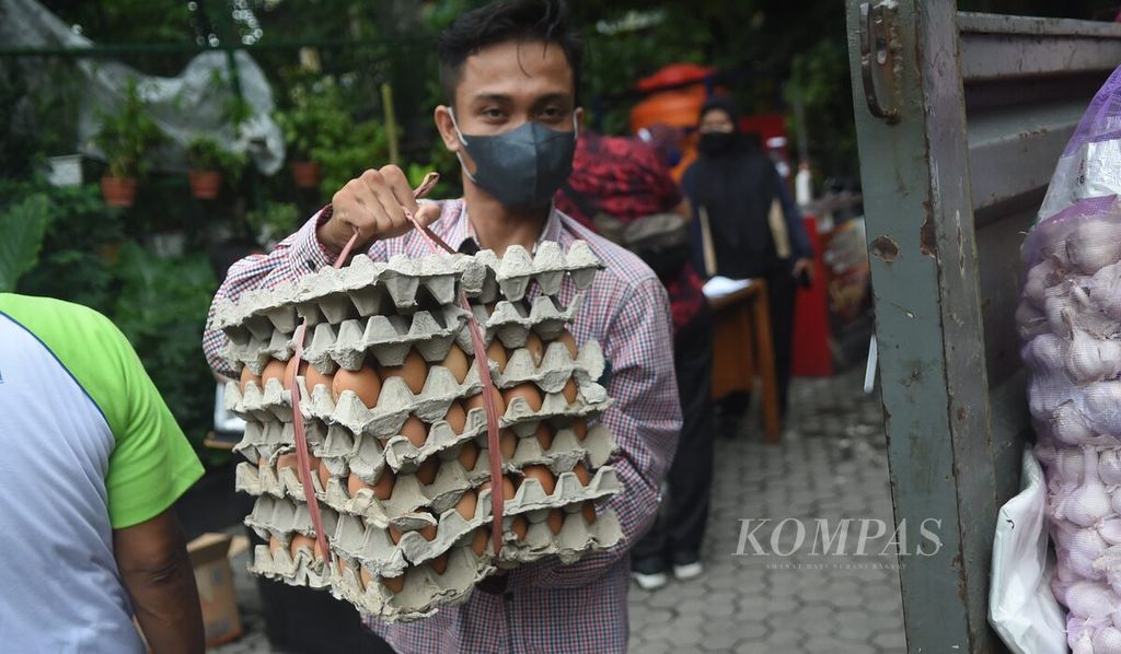 Petugas membawa telur yang akan dijual saat operasi pasar di Kantor Kelurahan Asemrowo, Surabaya, Jawa Timur, Jumat (3/12/2021). 