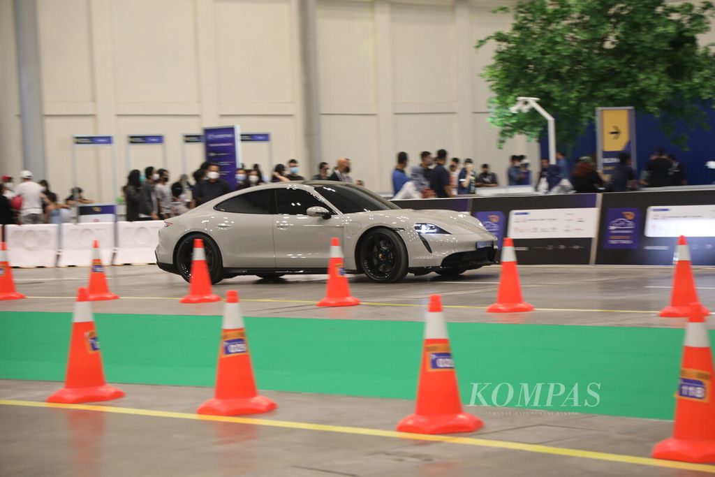 Pengunjung menguji kendara mobil listrik performa tinggi, Porsche Taycan, di arena tes khusus dalam GIIAS 2022 di Hall 10 ICE BSD, Tangerang, Banten, Jumat (12/8/2022). 