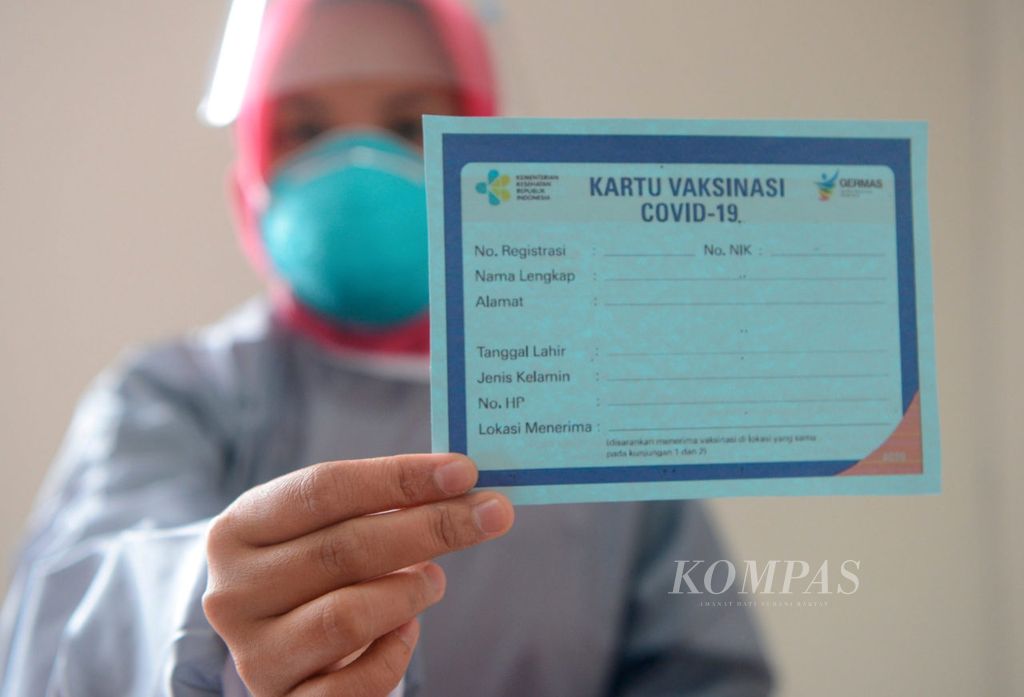 Petugas menunjukan kartu vaksinasi Covid-19 bagi mereka yang telah vaksin di Puskemas Pandanaran, Kota Semarang, Jawa Tengah, Kamis (14/1/2021).