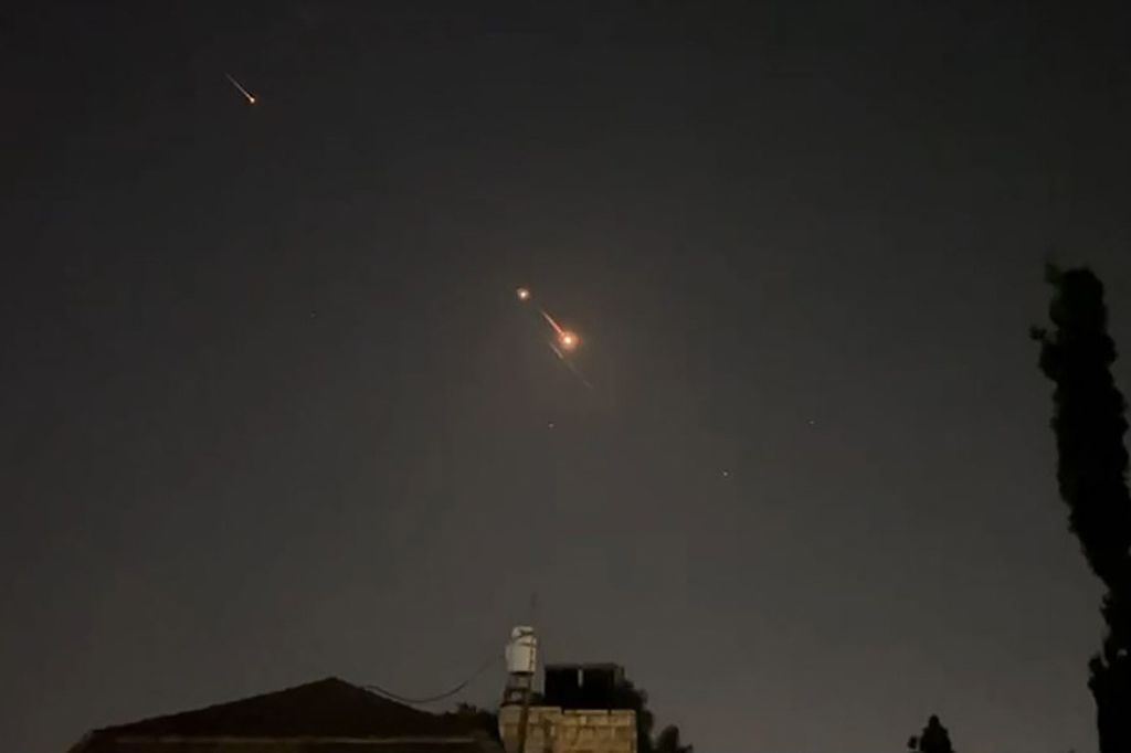 Gambar yang diambil dari video AFPTV, Minggu (14/2024), memperlihatkan cahaya akibat ledakan di langit Jerusalem dalam serangan Iran ke Israel. 