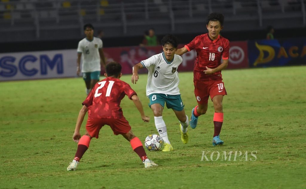 Pemain Indonesia Zanadin Fariz (tengah) dengan membawa bola berusaha melewati pemain Hong Kong Law Cheuk Hei dalam Laga Kualifikasi Piala Asia U-20 di Stadion Gelora Bung Tomo, Kota Surabaya, Jawa Timur, Jumat (16/9/2022). Indonesia menang 5-1. 