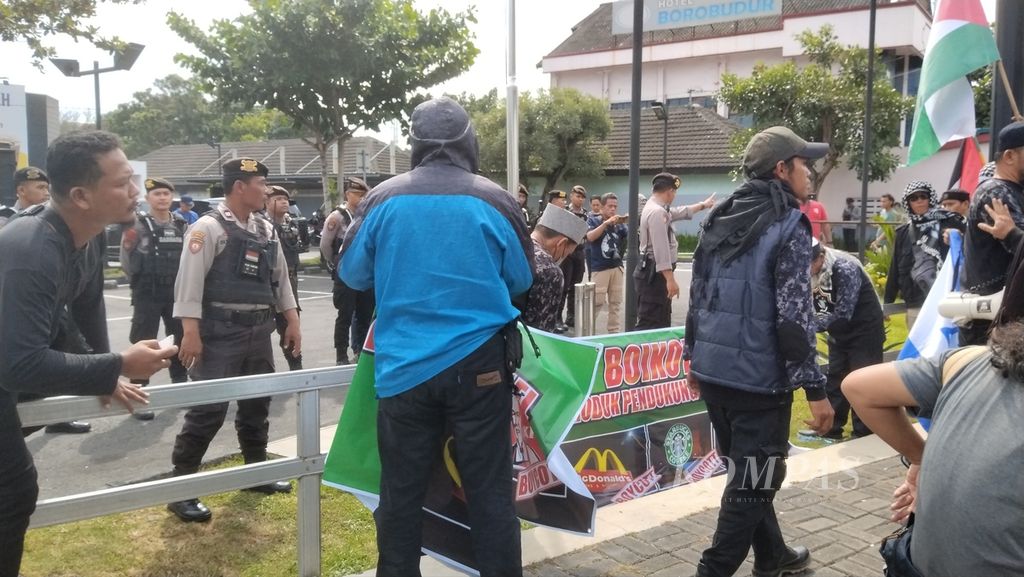 Massa dari Aliansi Umat Islam Se-DIY-Jateng memasang spanduk boikot di depan sebuah restoran cepat saji di Kabupaten Sleman, DI Yogyakarta, Minggu (19/5/2024).
