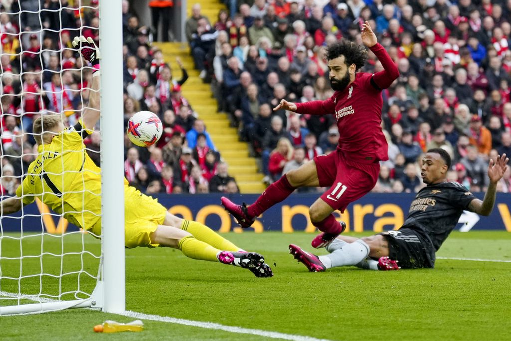 Pemain Liverpool Mohamed Salah (tengah) mencetak gol ke gawang Arsenal pada laga Liga Inggris di Stadion Anfield, Liverpool, Minggu (9/4/2023). Laga berakhir imbang 2-2. 