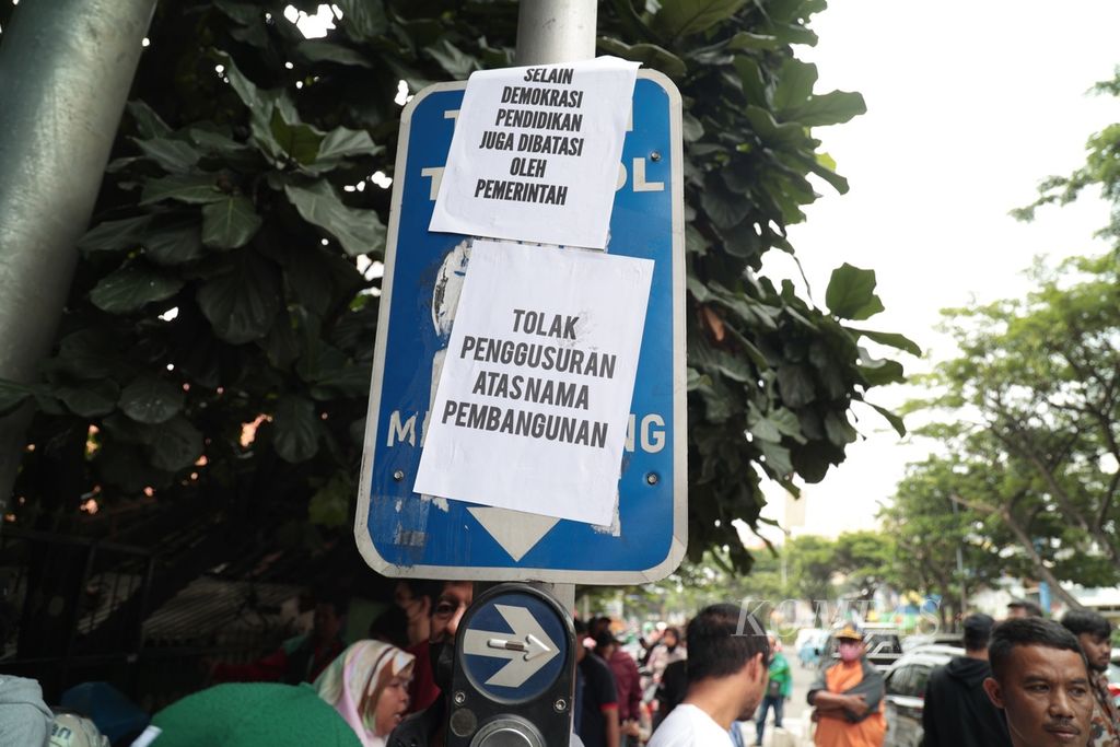 Poster kecaman terkait penggusuran sekolah yang akan dilakukan petugas Satuan Polisi Pamong Praja Kota Depok terpasang di rambu depan SDN Pondok Cina 1, Depok, Jawa Barat, Minggu (11/12/2022). 