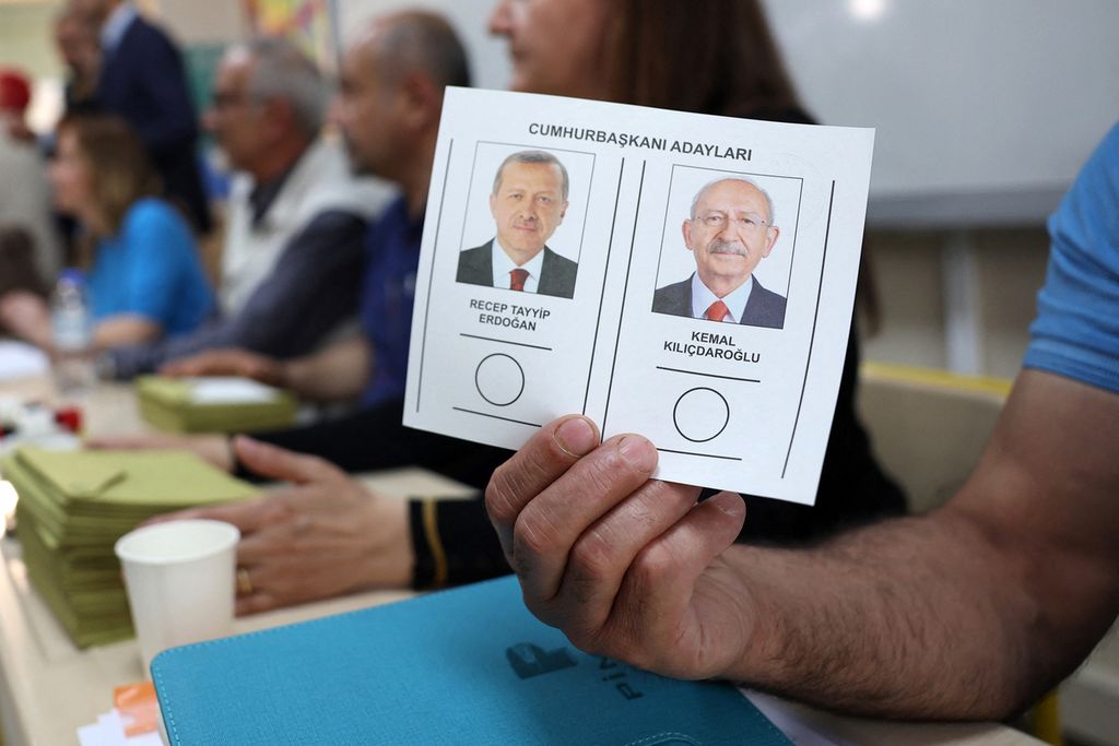 An election official shows a ballot paper featuring the two candidates, Recep Tayyip Erdogan (L) and Kemal Kilicdaroglu at a polling station during the presidential runoff vote in Ankara on May 28, 2023. Turkey votes on May 28, 2023 in a historic runoff that Turkish President enters as the firm favourite to extend two decades of his Islamic-rooted rule to 2028.