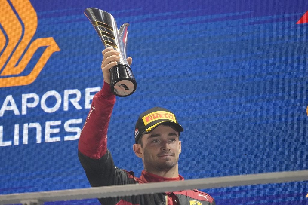 Pebalap tim Ferrari Charles Leclerc merayakan keberhasilannya menempati posisi podium kedua pada F1 seri Singapura di Marina Bay Street Circuit, Singapura, Minggu (2/10/2022). 
