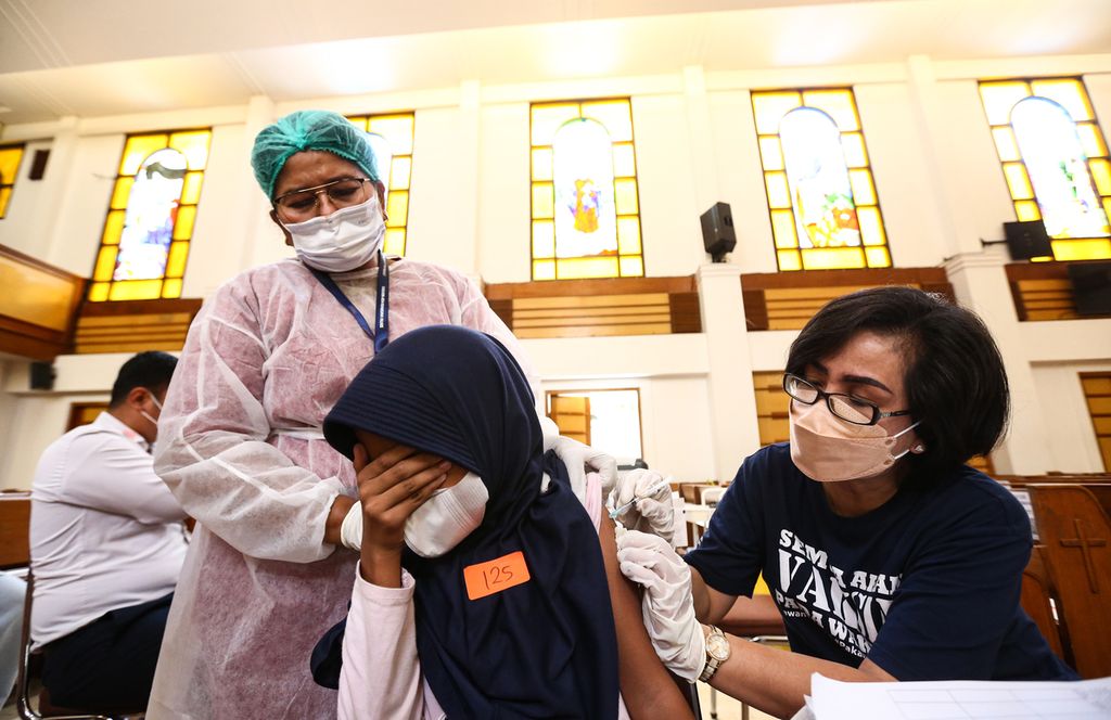 Seorang anak menutup matanya saat menerima suntikan vaksin Covid-19 dosis kedua di sentra vaksin Gereja HKBP Menteng, Jakarta Pusat, Senin (24/1/2022). 