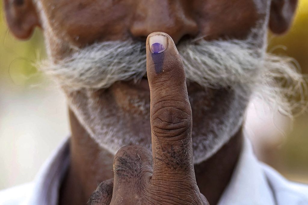 Seorang pemilih memperlihatkan jarinya yang diberi tinta setelah memberikan suara di tempat pemungutan suara pada pemilu tahap ketiga India di Desa Gola, Banaskantha, Negara Bagian Gujarat, 7 Mei 2024. 