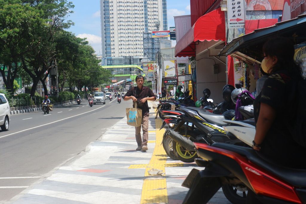 Suasana trotoar di depan SD Negeri Pondok Cina 1, Jalan Margonda Raya, Depok, Jawa Barat, Selasa (29/11/2022). Terlihat pejalan kaki sedang menggunakan trotoar. Terlihat pula sejumlah sepeda motor diparkir di trotoar tersebut.