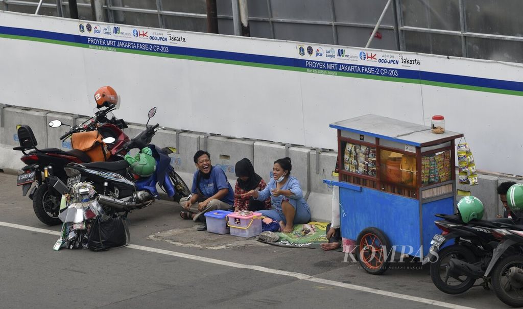 Penjual makanan keliling mangkal di dekat proyek MRT Jakarta fase 2A paket kontrak (CP) 203 di kawasan Glodok, Jakarta Barat, Rabu (24/11/2021). 