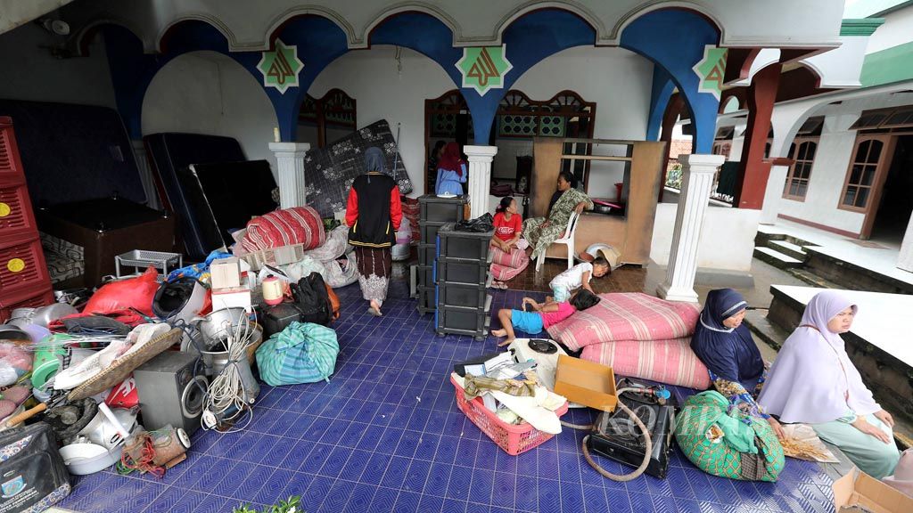 Warga korban  bencana longsor di Kelurahan Kranggan, Kecamatan Setu, Kota Tangerang Selatan mengungsi di masjid setempat bersama perabotan rumah mereka, Rabu (10/5). Kejadian longsor berlangsung pada Selasa (9/5) malam.  Tidak ada korban jiwa dalam kejadian tersebut, namun sebanyak lima rumah hancur dan sejumlah lainnya masih terancam longsor susulan dalam bencana tersebut.