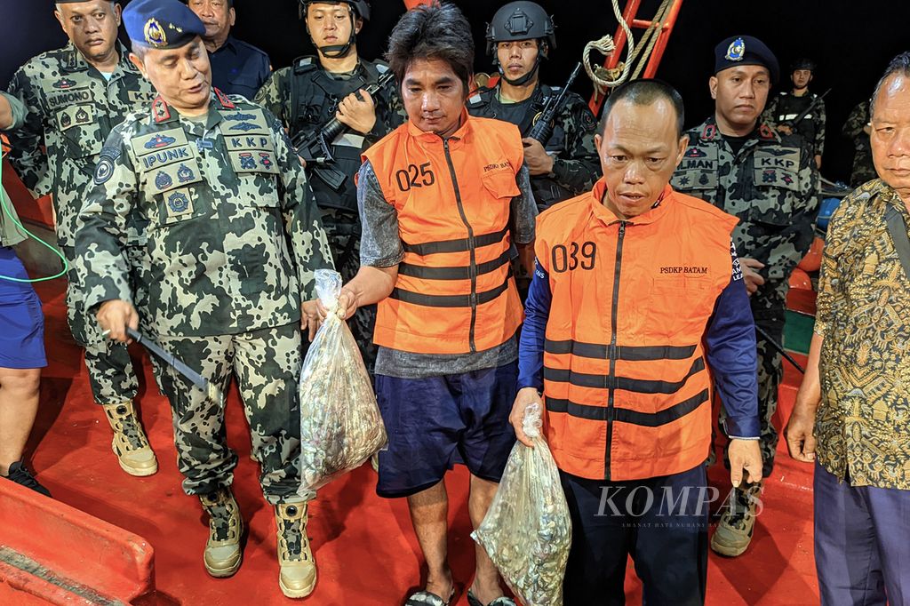 Pelaksana Tugas Direktur Jenderal PSDKP-KKP Pung Nugroho Saksono (kiri) menunjukkan ikan-ikan berukuran kecil yang ditangkap kapal pukat harimau Vietnam saat konferensi pers di Pangkalan PSDKP Batam, Sabtu (4/5/2024) malam.