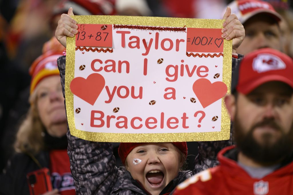 Seorang penggemar muda Kansas City Chiefs memegang poster yang ditujukan kepada Taylor Swift selama paruh kedua pertandingan sepak bola NFL melawan Cincinnati Bengals, 31 Desember 2023, di Kansas City, AS.