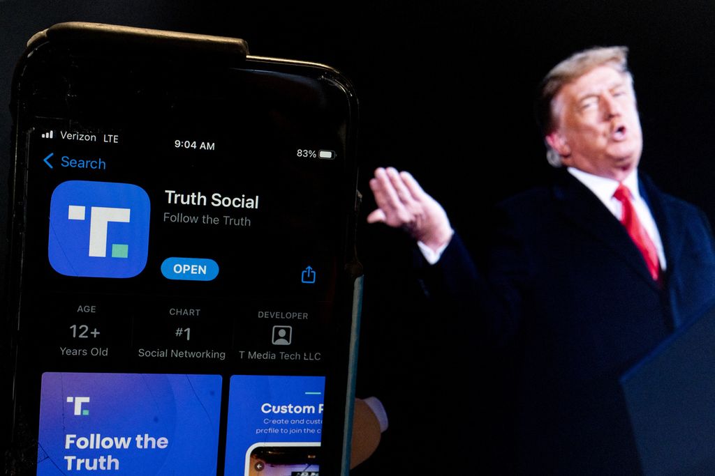 Ilustrasi foto ini menunjukkan mantan Presiden AS Donald Trump di samping layar ponsel yang menampilkan aplikasi Truth Social, di Washington DC, pada 21 Februari 2022. 