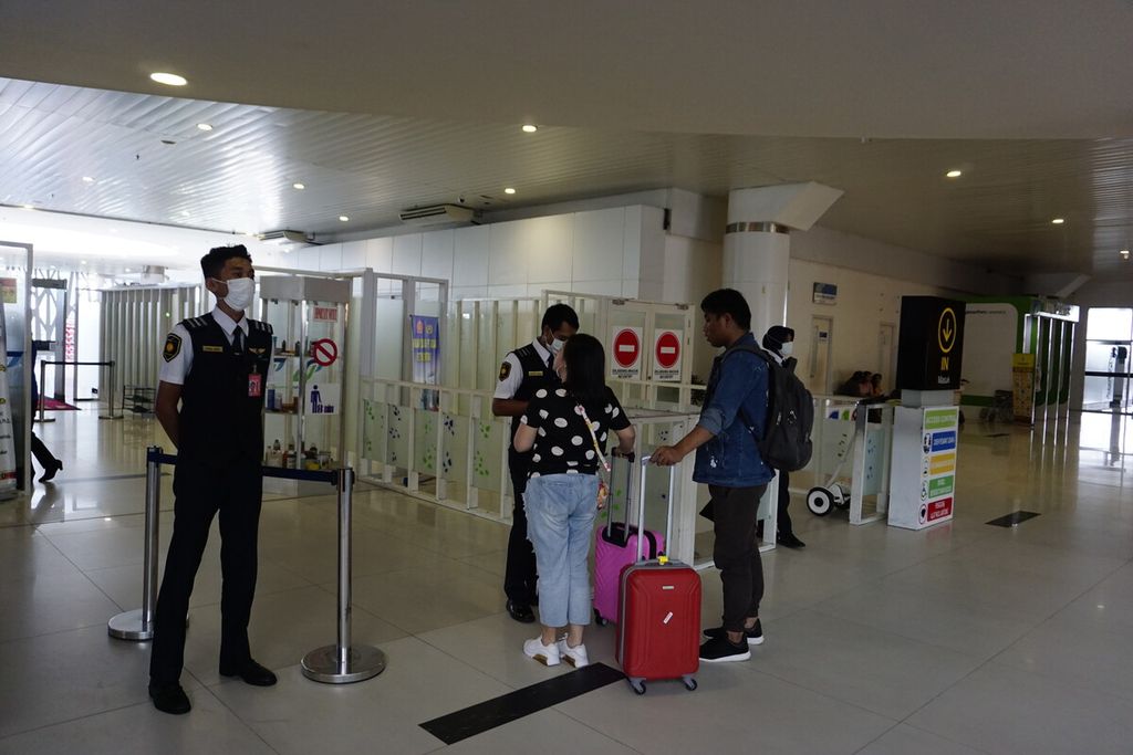 Petugas di Bandara Sultan Aji Muhammad Sulaiman Sepinggan, Balikpapan, mengenakan masker saat memeriksa tiket penumpang di Balikpapan, Kalimantan Timur, Senin (27/1/2020).