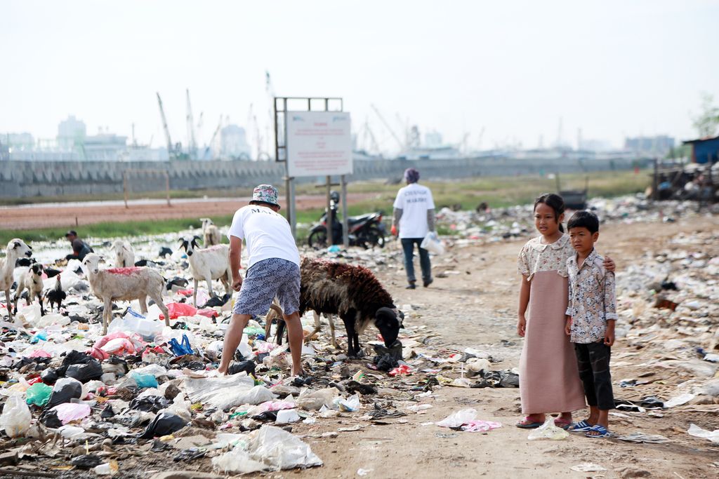 Anak-anak melihat warga membersihkan sampah di acara <i>Antheia Beach Clean Up Vol. 4 #SayNoToStyrofoam</i> di Kampung Muara Baru, Penjaringan, Jakarta Utara, Sabtu (03/12/2022).